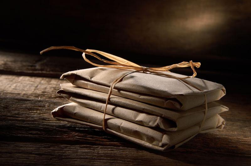 褐色背景下木桌上的扎好的纸包装