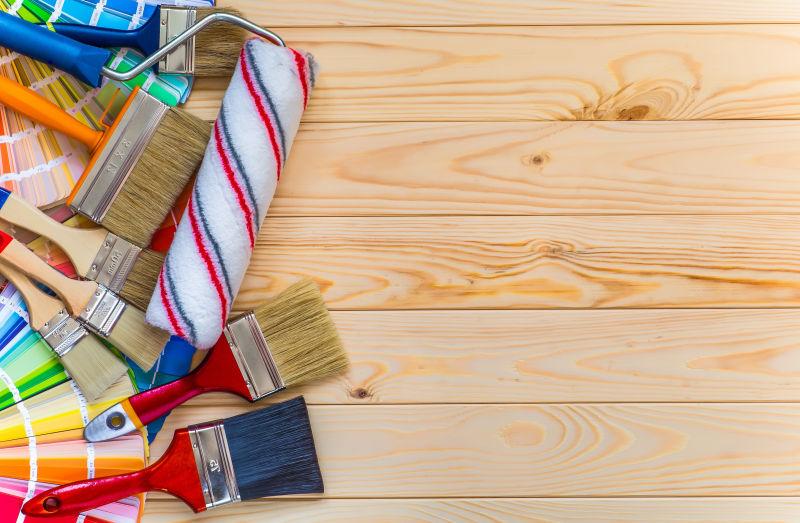 木桌背景上的一堆刷子和油漆色卡