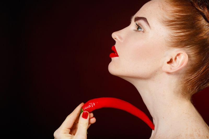 黑色背景中的美女与辣椒