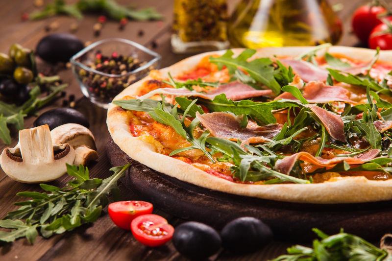 木桌上有熏肉和芝麻菜的比萨饼