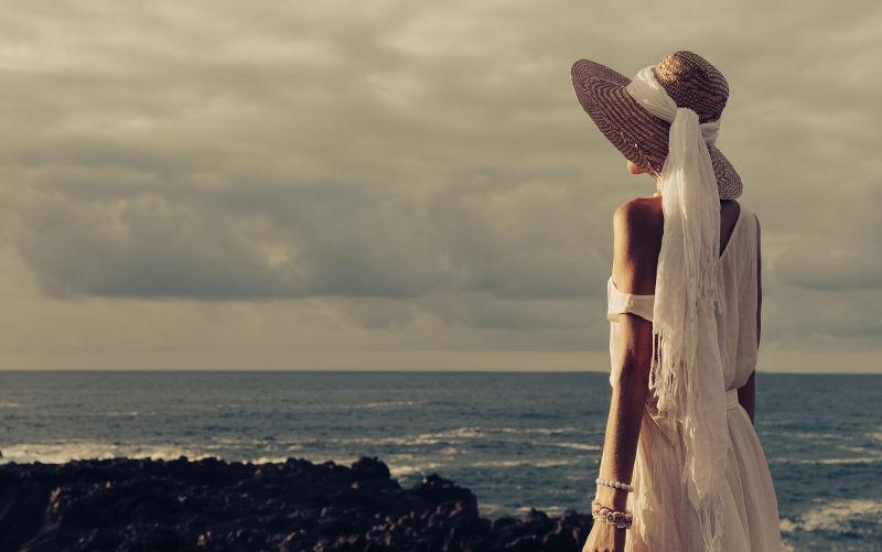 站在沙滩上度假的年轻美女