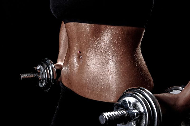 使用哑铃进行健身的女子的身材