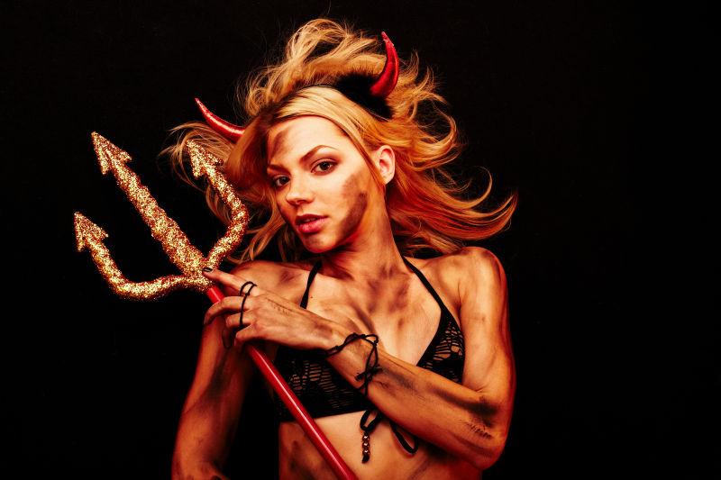 黑色背景中穿性感内衣的万圣节女战士