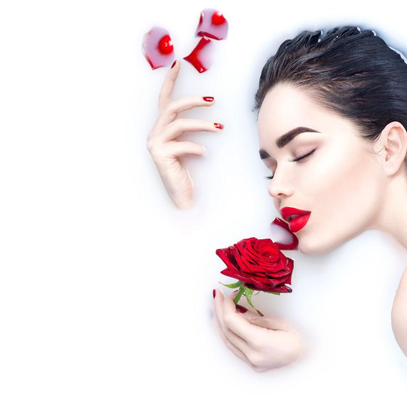 手拿红色玫瑰花泡牛奶的美女