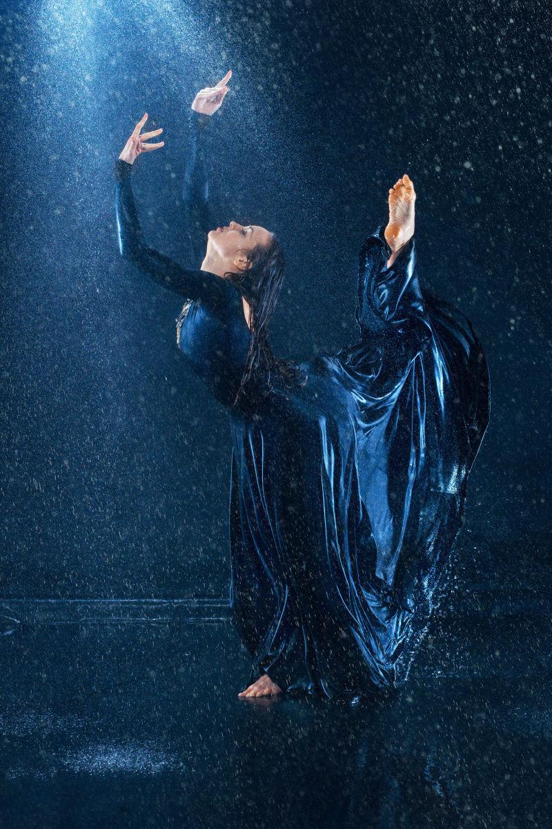 年轻美丽的现代舞蹈家在雨中跳舞
