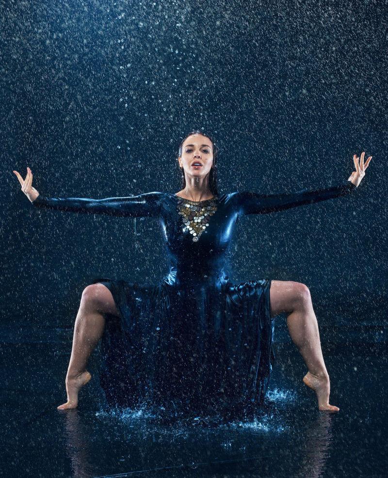 年轻美丽的现代舞蹈家在雨中跳舞