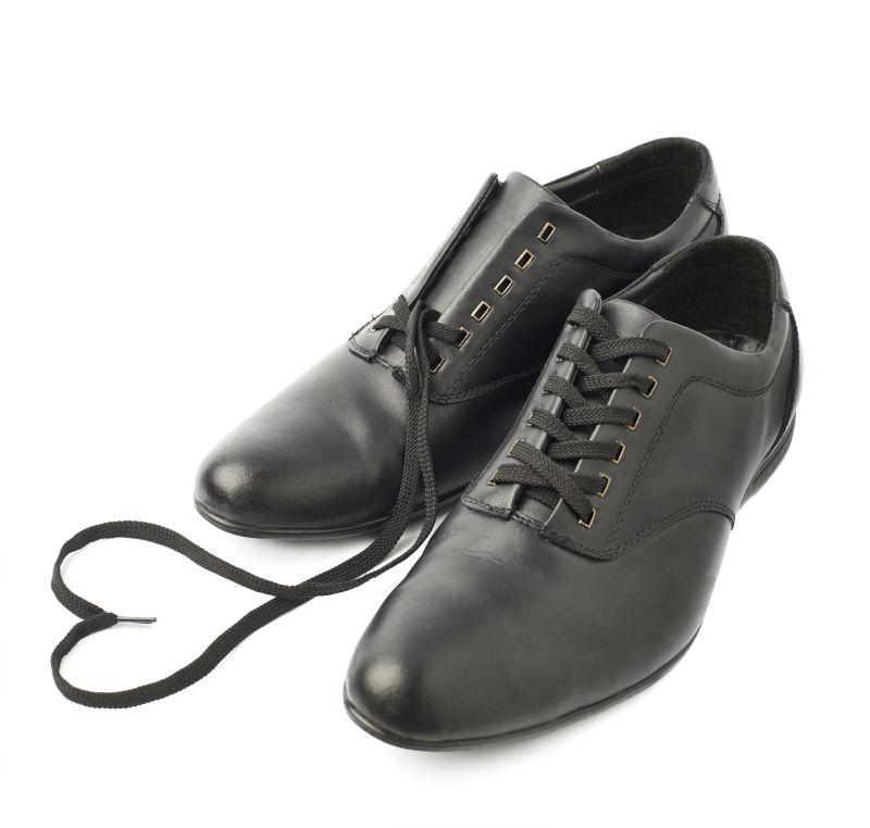 白色背景上的黑色皮鞋与心形鞋带