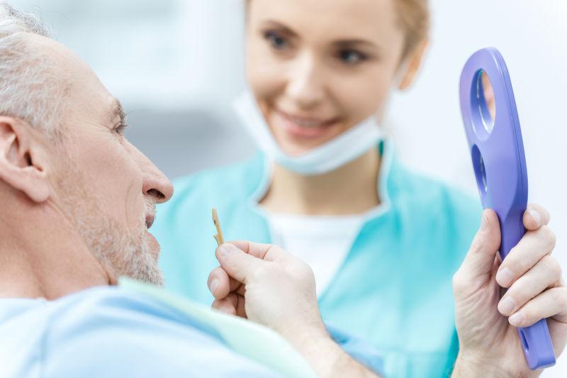 拿着镜子对比牙齿的病和牙医