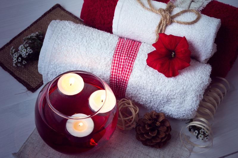 桌上的毛巾与玻璃碗中的芳香疗法水与鲜花