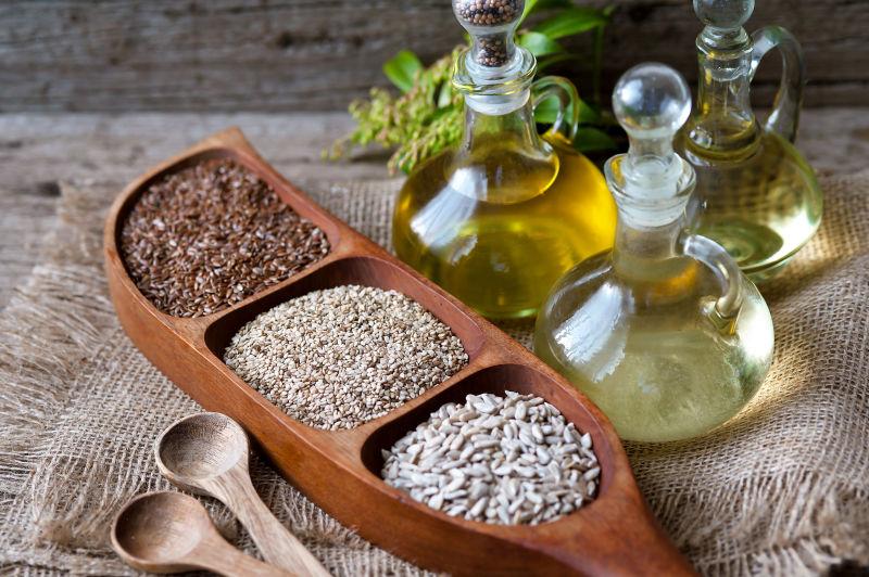 芝麻和向日葵种子与精油在木桌上