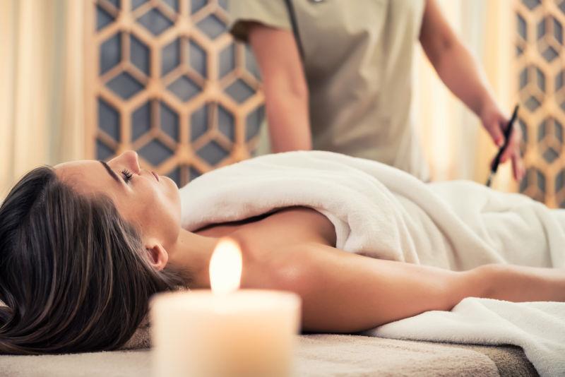 美容美发中心按摩床上的年轻女士