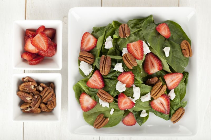 白色木桌上的水果菠菜沙拉