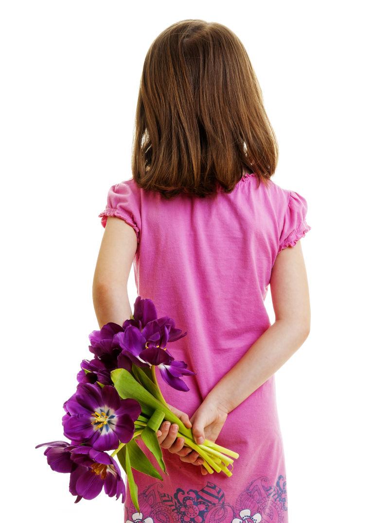 白色背景下拿鲜花的小女孩背影