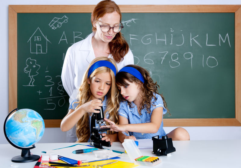 使用显微镜的小学女生