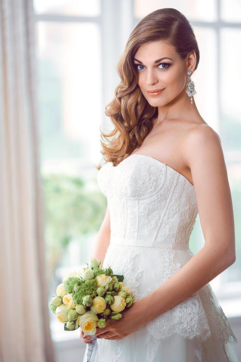 端庄的新娘拿着美丽的花束