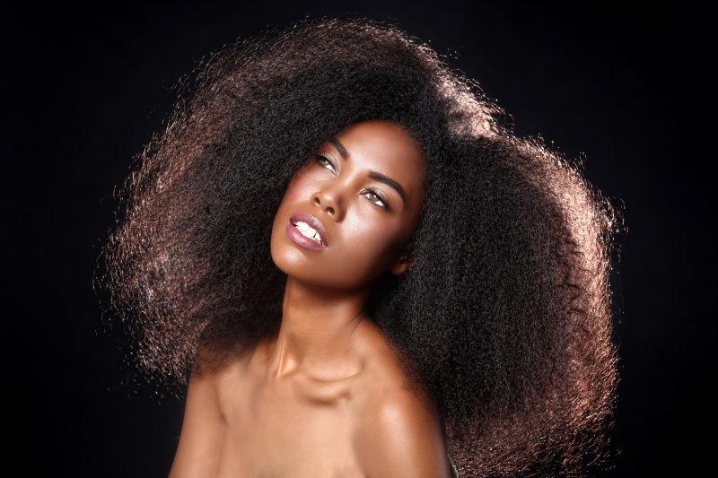 黑色背景前的爆炸头黑人美女