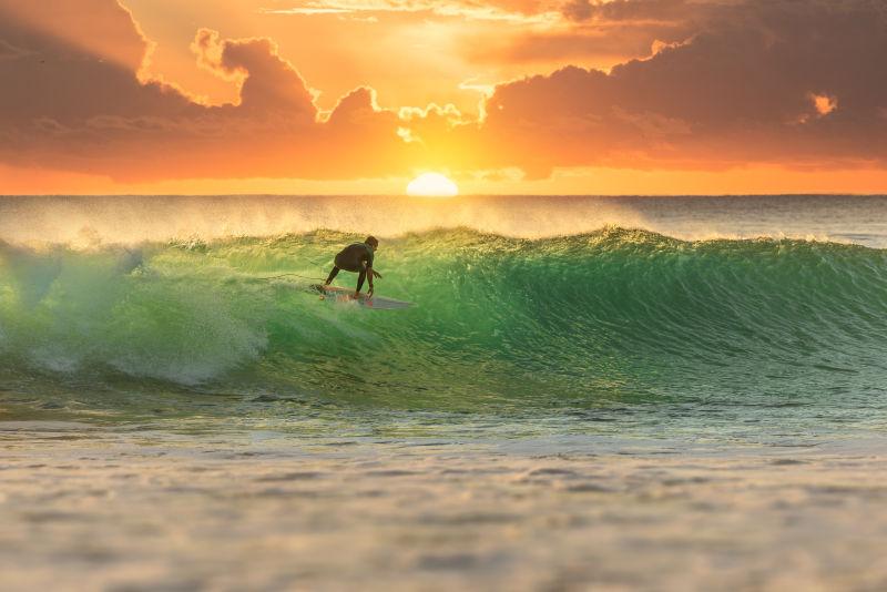 日出的海面上冲浪的人