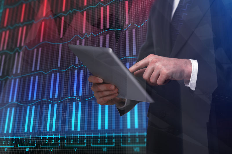 外汇图表背景前的商人使用平板电脑