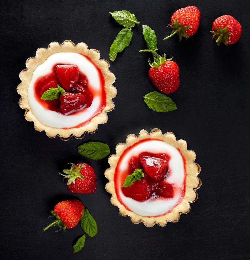 黑色背景上的草莓和香草奶油馅饼