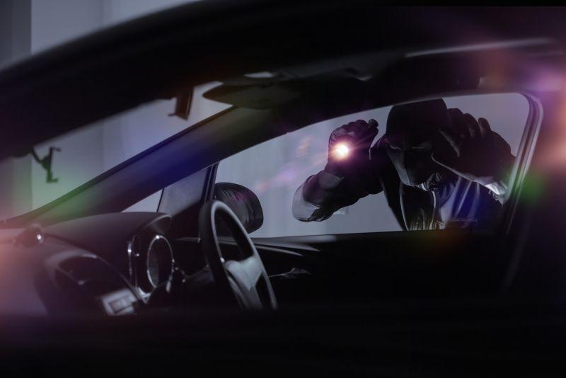 汽车外拿着手电筒的小偷