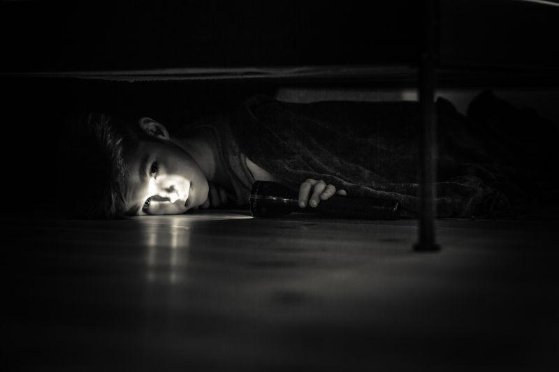 床下拿着手电筒的男孩