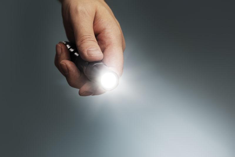 男人手里发亮的手电筒