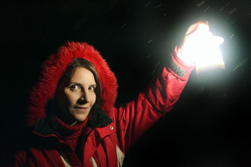 黑暗中拿着手电筒的女人