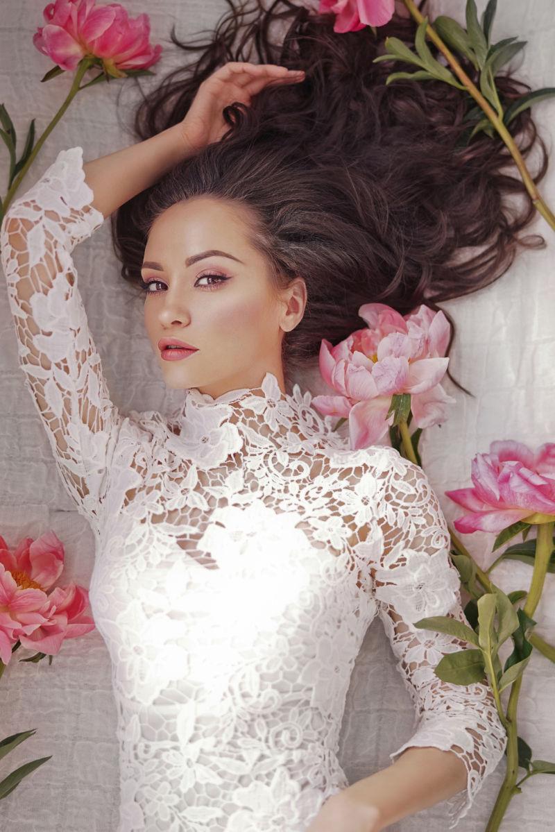 被牡丹花包围的穿着白色蕾丝的美女