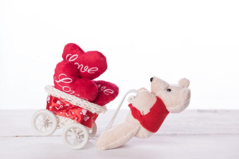 可爱的泰迪熊带着爱的心在白色自行车上