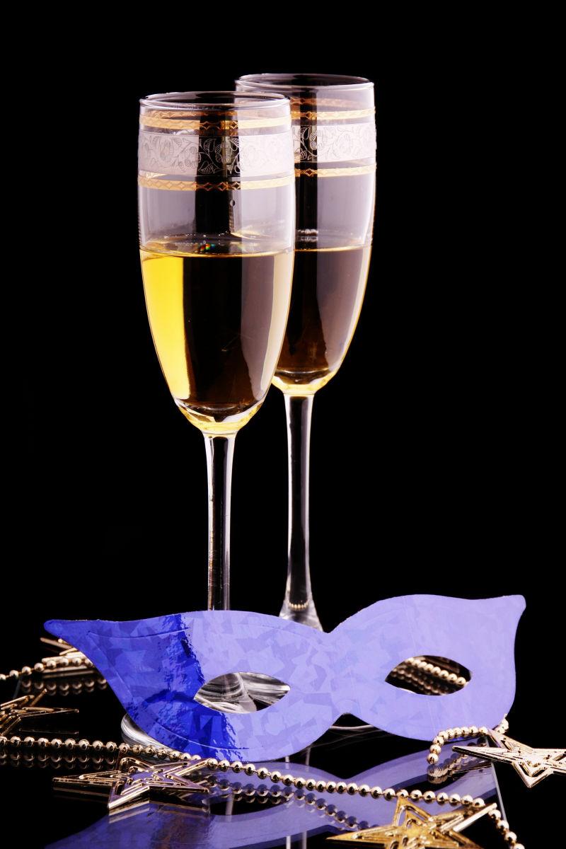 两杯高脚杯里的酒和狂欢节面具