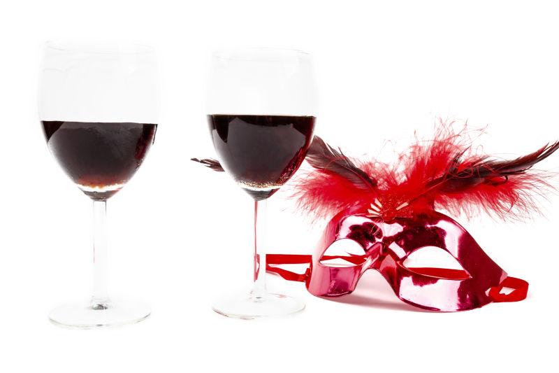 高脚杯里的酒和红色面具