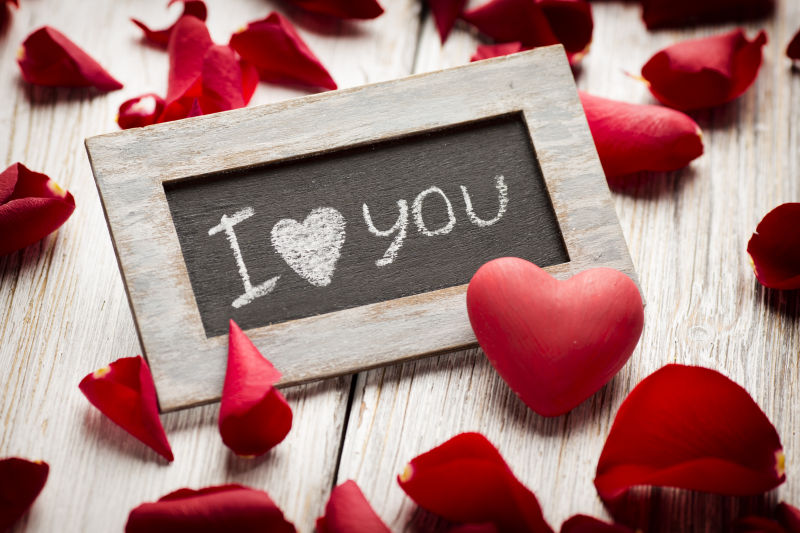 木板上的相框和爱心花瓣