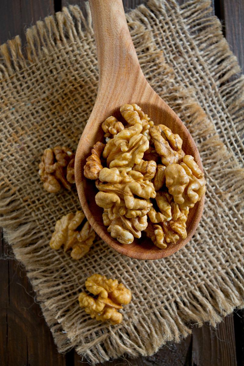 黑色背景上勺子里的核桃仁