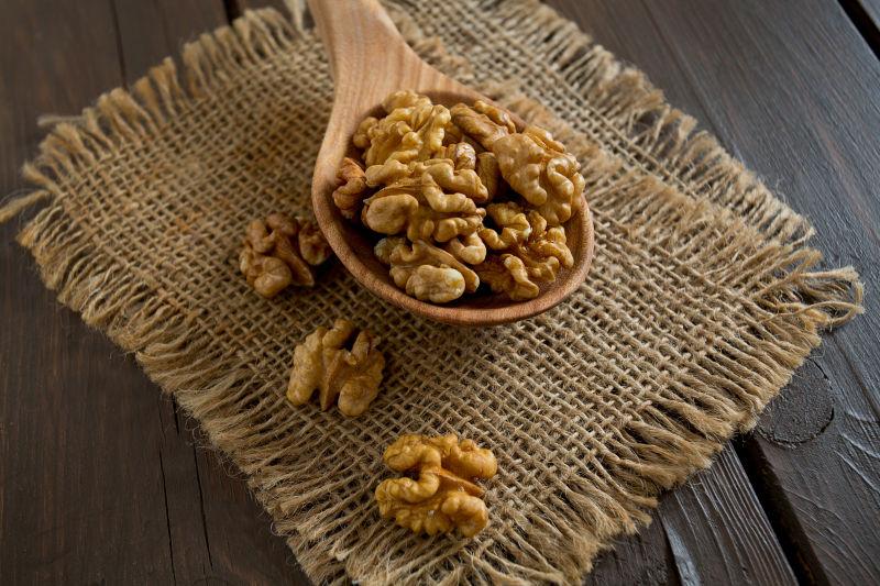 木板上木勺里的核桃仁