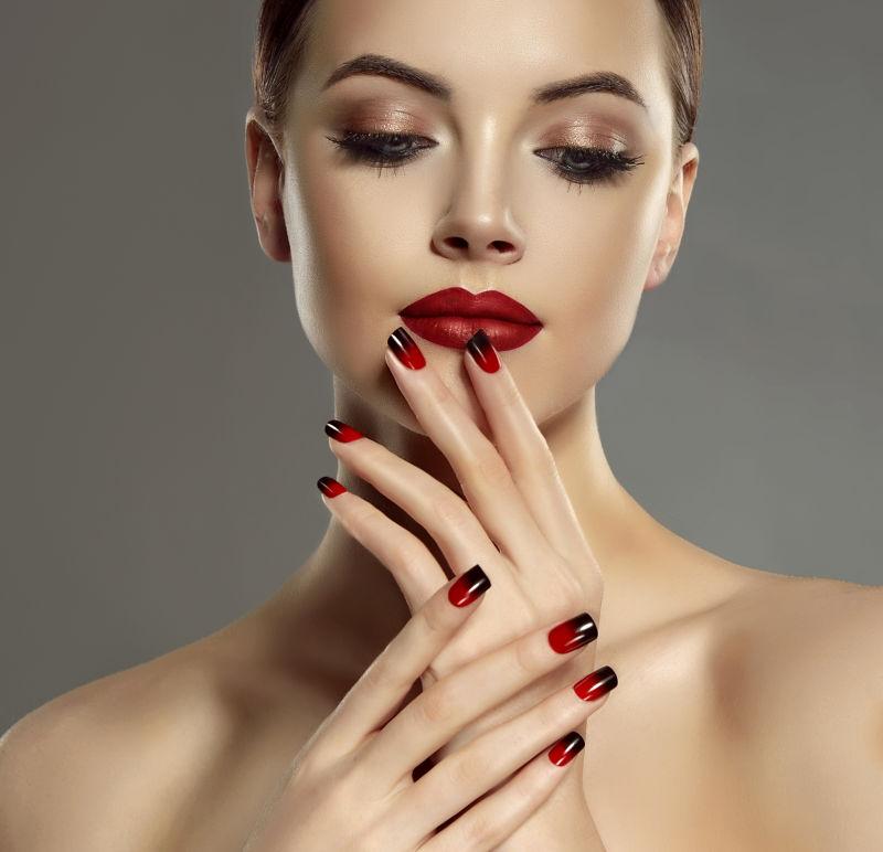 有红色和黑色法式指甲的美丽的模特女孩