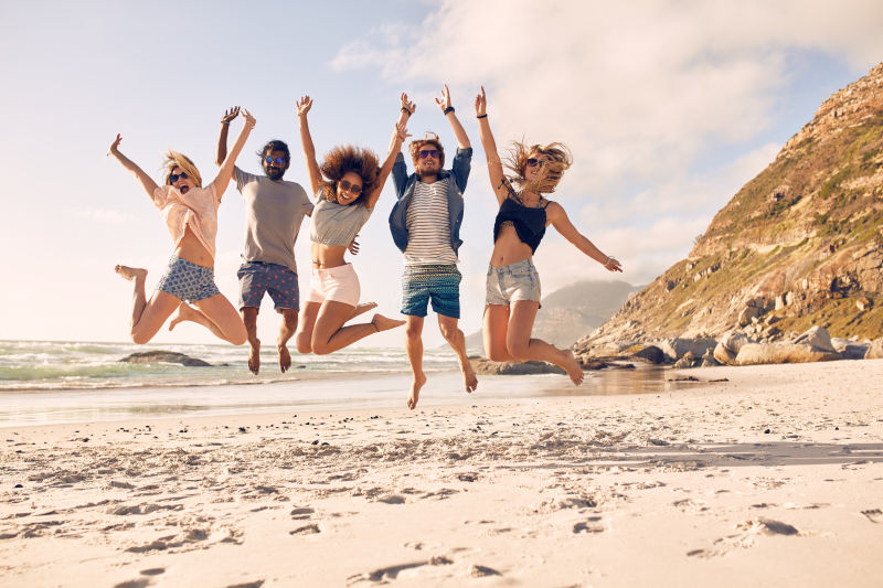 海滩上的一群朋友跳跃玩的开心