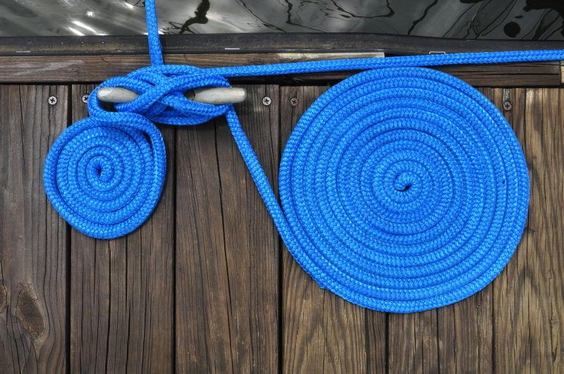 两根蓝色绳索固定船停泊