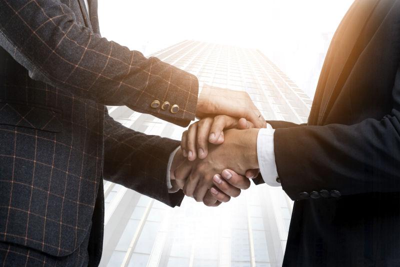 大厦楼下握手的商人