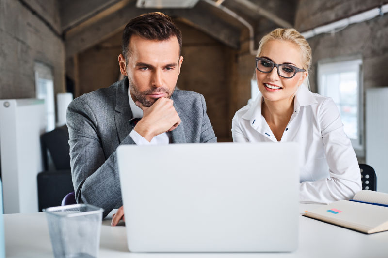 室内凝视笔记本电脑的商人