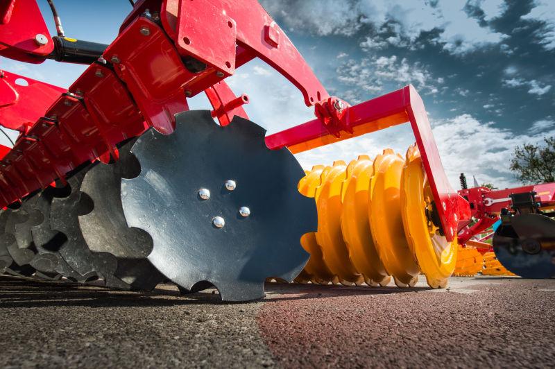 蓝天白云下的红色和黄色的农业机械