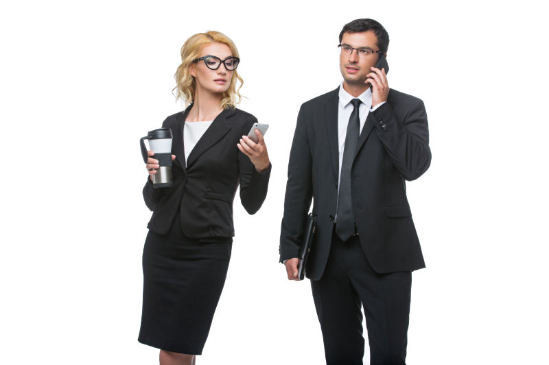 戴着眼镜喝着咖啡的商务小姐和手机聊天英俊的商人