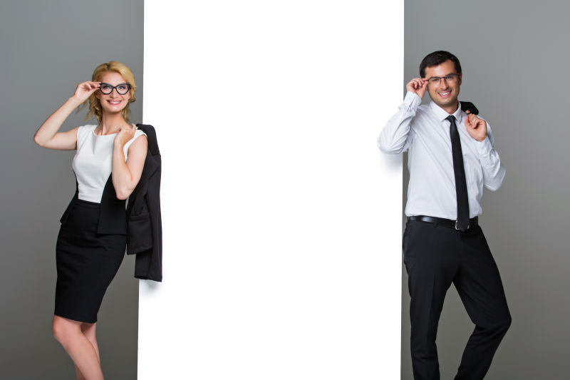 站在大空海报旁的有魅力的男女商人