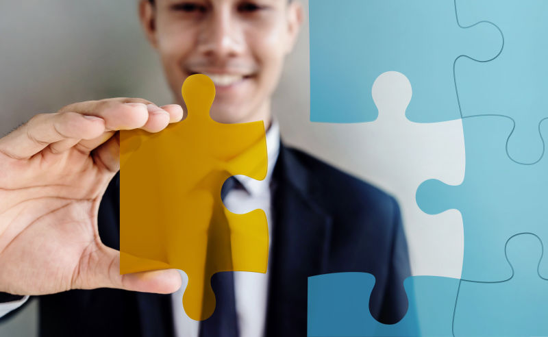 拿着橙色拼图的商人