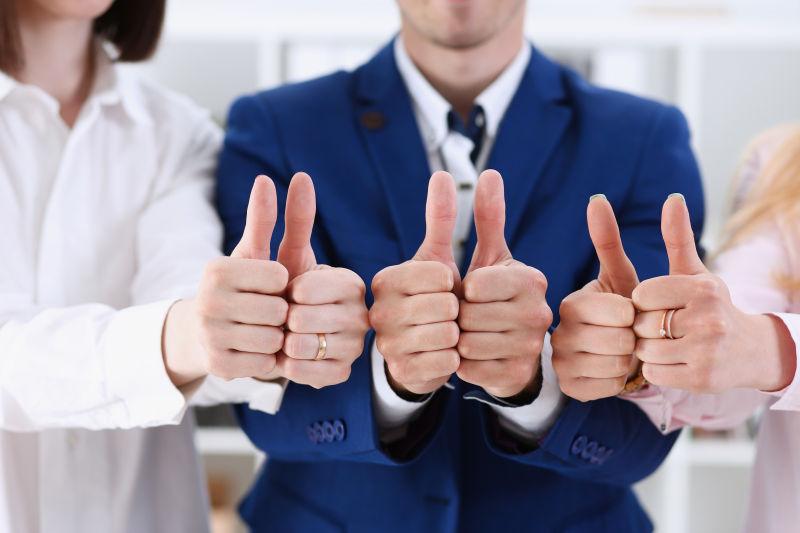 在会议闭幕期间一群人用大拇指显示OK或批准