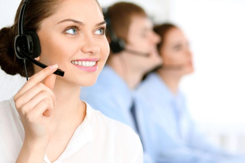 带着黑色头戴式耳机的微笑的女客服