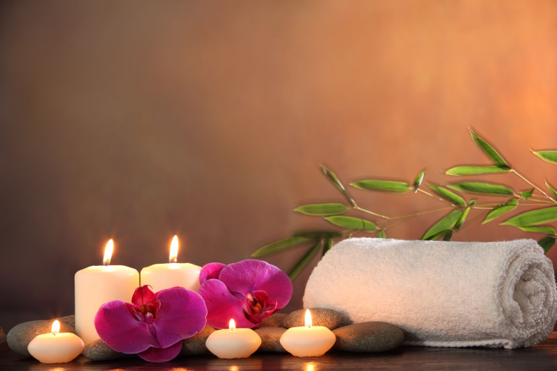 棕色背景前的蜡烛和毛巾