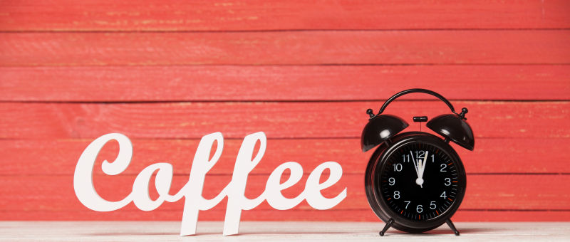写着咖啡的木墙前放着黑色的闹钟