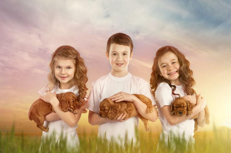 三个抱着宠物狗的孩子