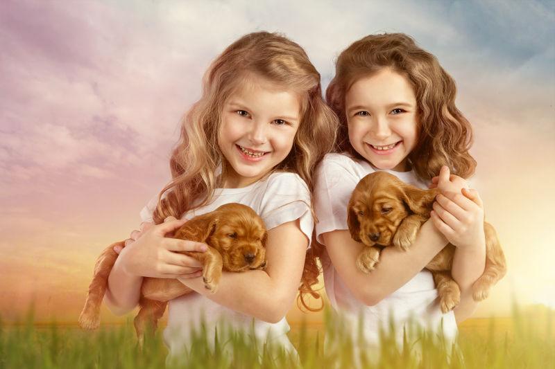 两个抱着宠物狗的小女孩