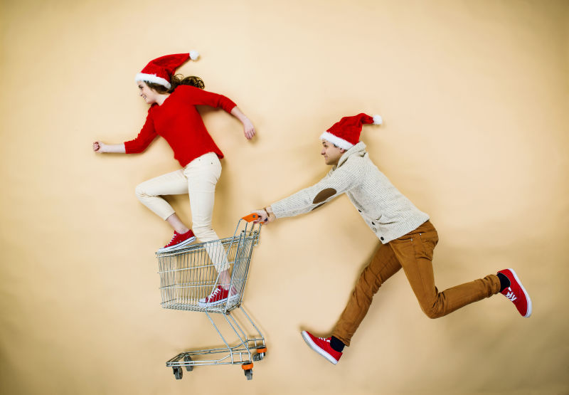 圣诞节推着购物车购物的年轻情侣